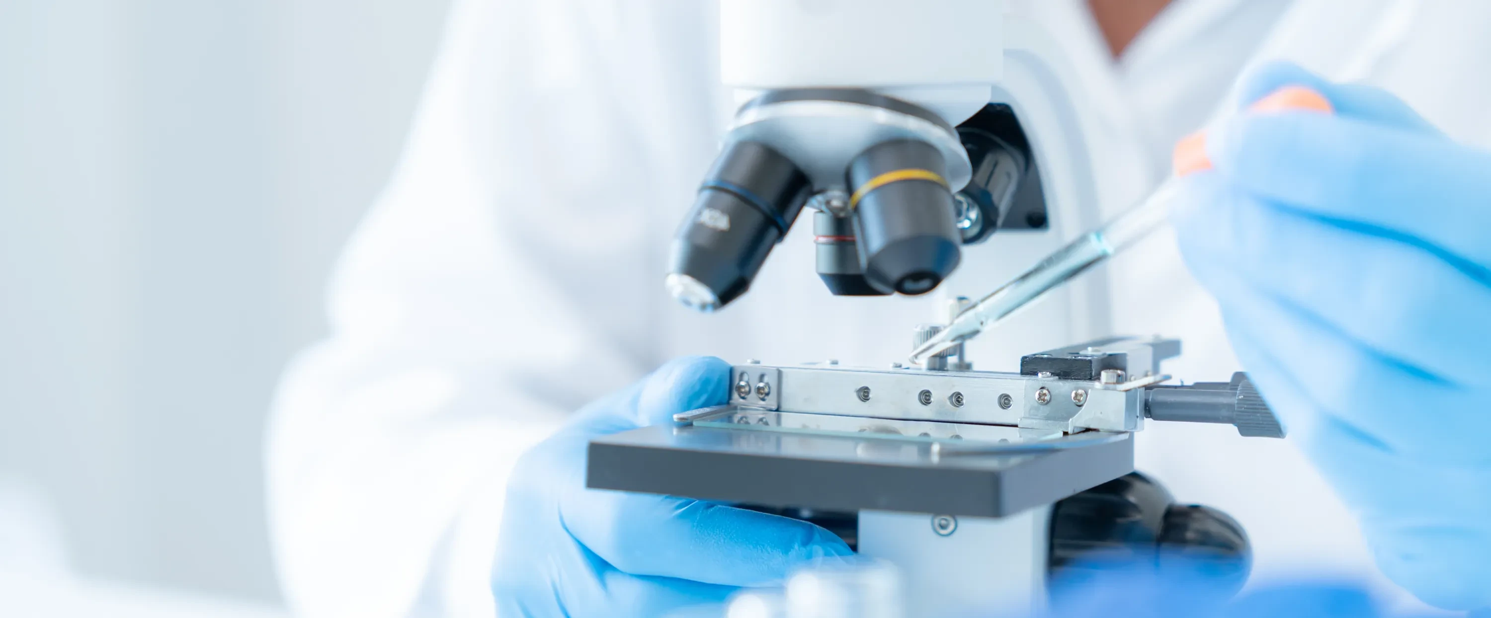 laboratory scientist looking at sample under a microscope