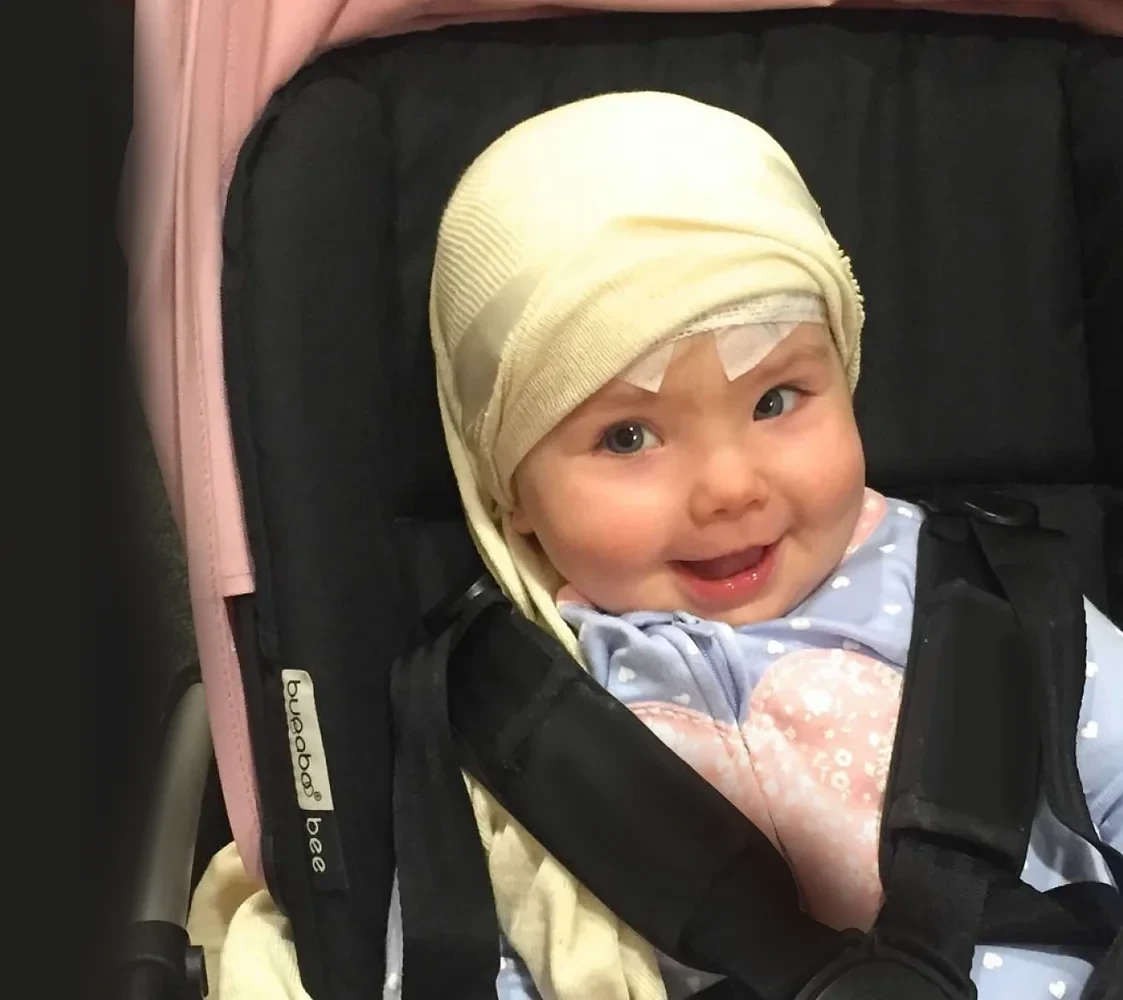 Young smiling girl patient siting in a pushchair